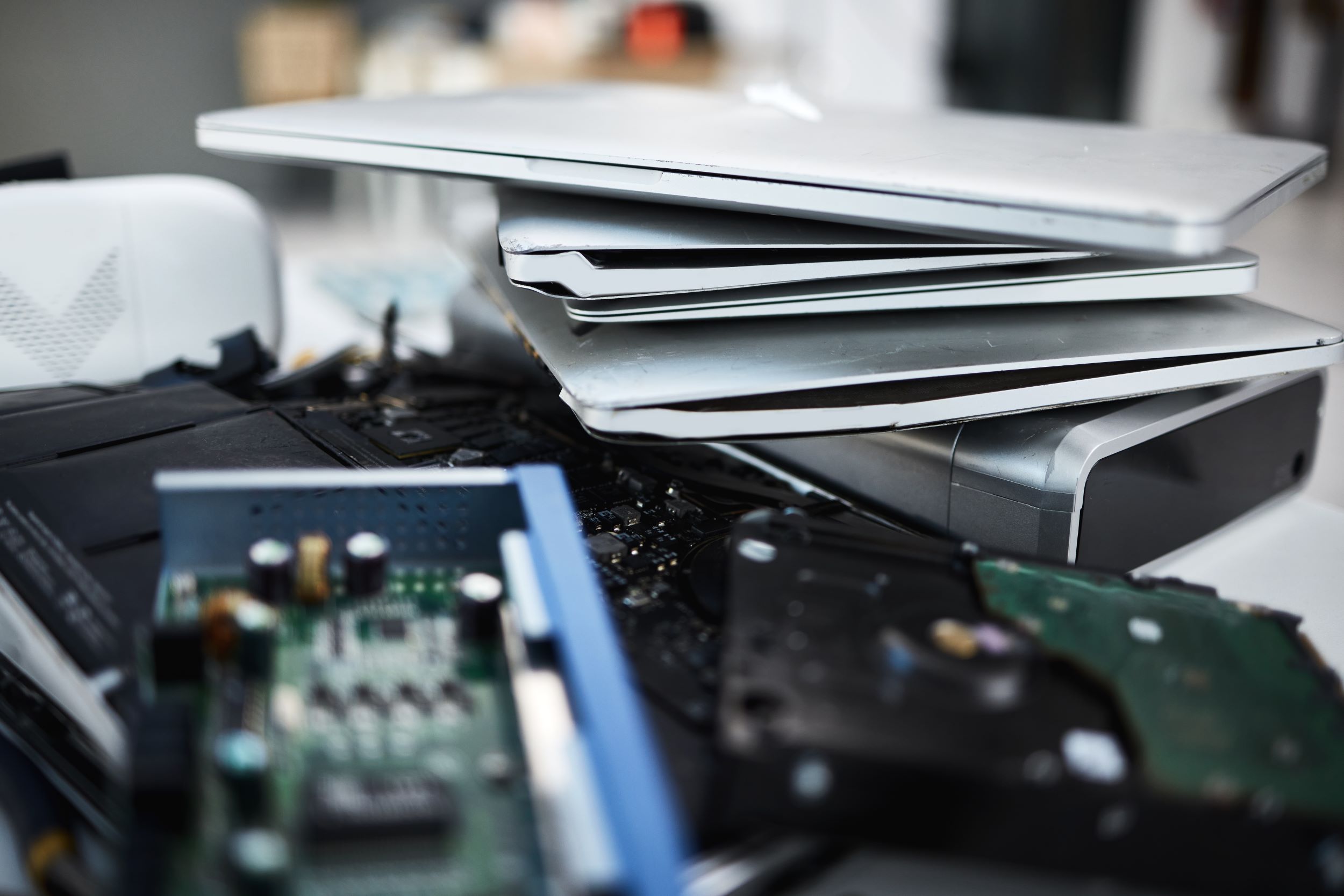 Stapel met computer hardware, laptops, harddisks