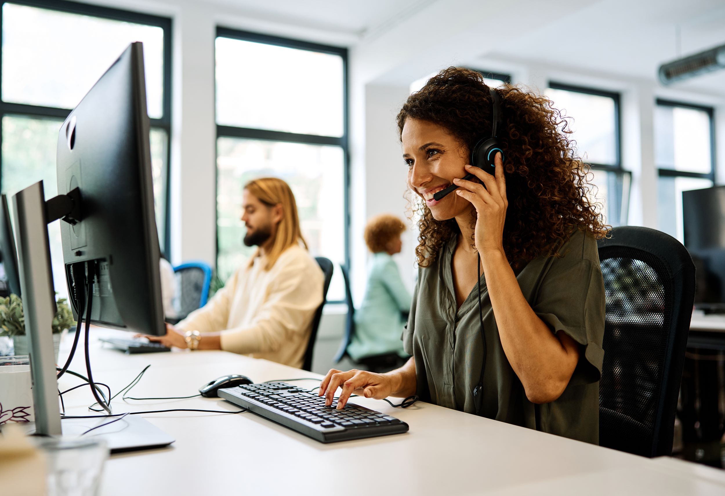 Werkende vrouw in een call center met headset en computer